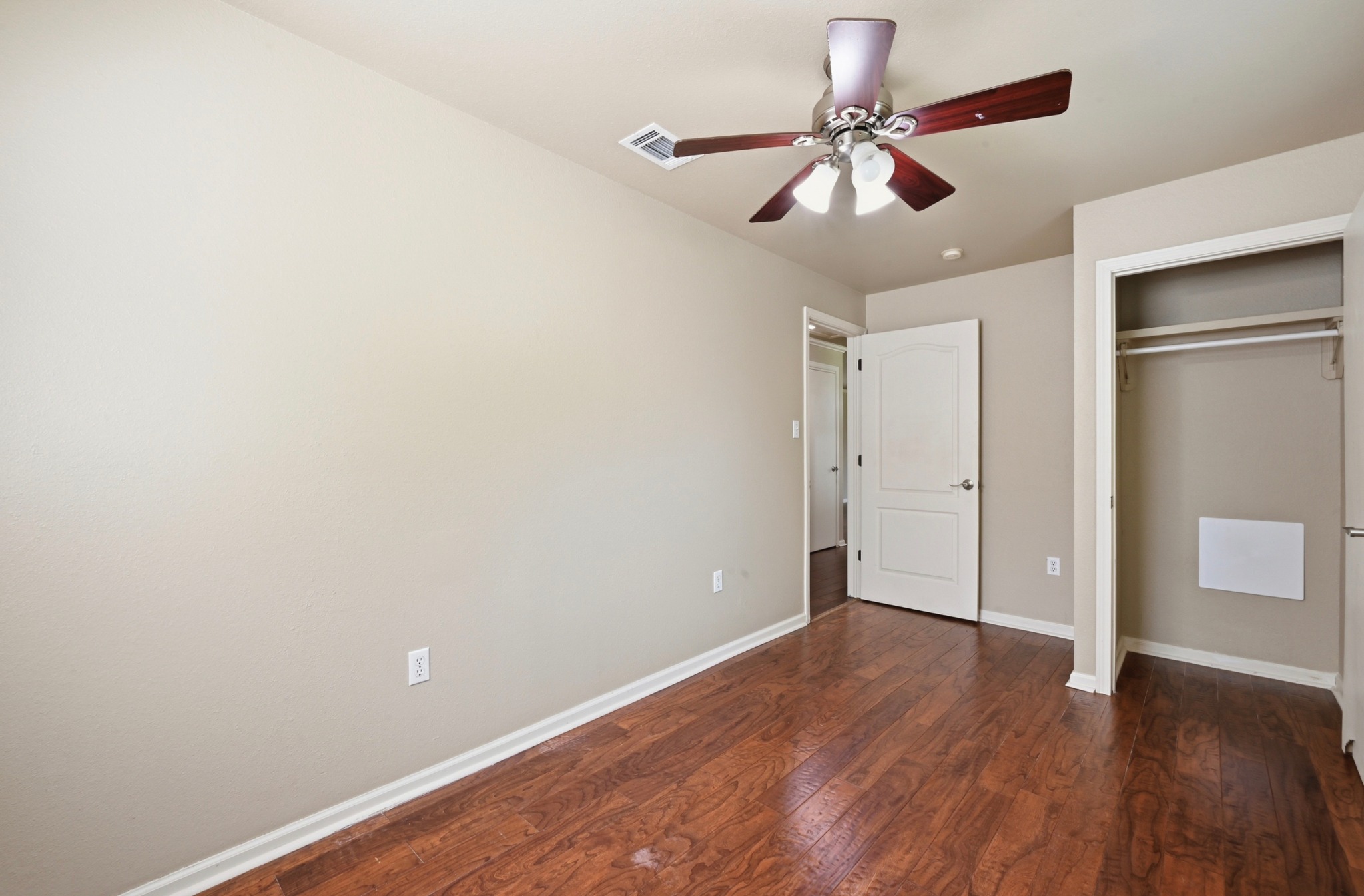 1127 Parr Street Luling, TX 78648 - Photo 13 of 20 Hardwood flooring extends throughout this naturally illuminated sleeping space, complete with a contemporary ceiling fan.
