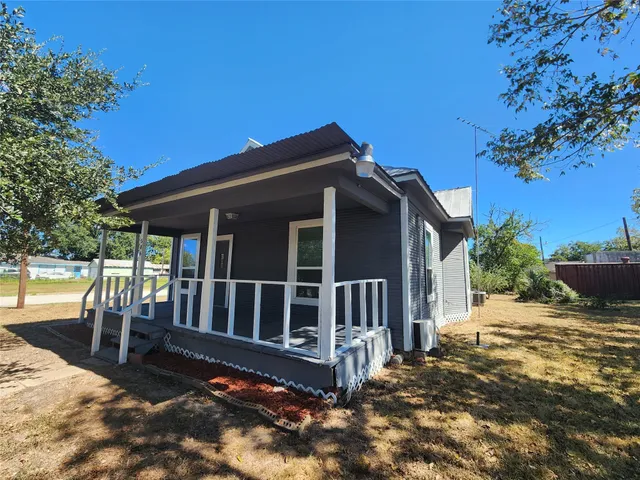 a view of a house with backyard and porch