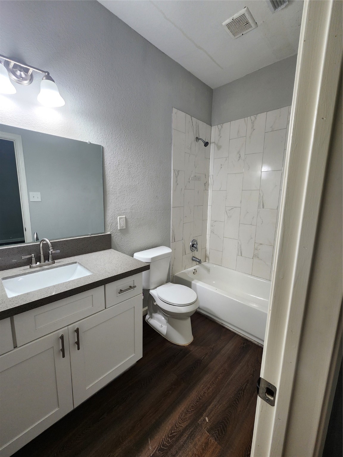 506 9th Street Hempstead, TX 77445 - Photo 9 of 23 a bathroom with a granite countertop sink toilet a large mirror a bathtub and shower