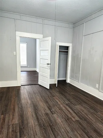 an empty room with wooden floor and closet