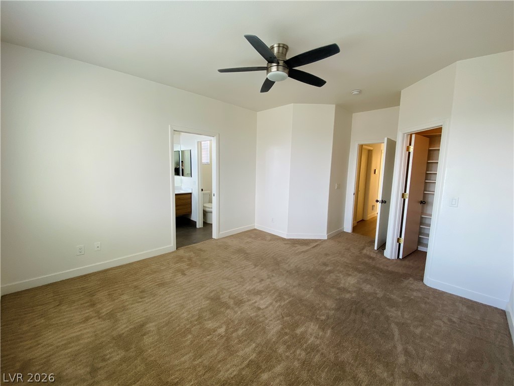 8794 Timber Mesa Street Las Vegas, NV 89139 - Photo 14 of 26 This spacious bedroom offers ample comfort and direct access to a private bathroom.