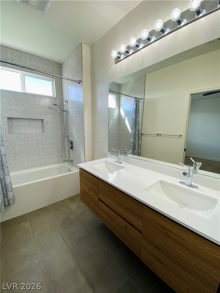 8794 Timber Mesa Street Las Vegas, NV 89139 - Photo 17 of 26 This modern bathroom features a sleek double vanity, ample mirror space, and contemporary fixtures.