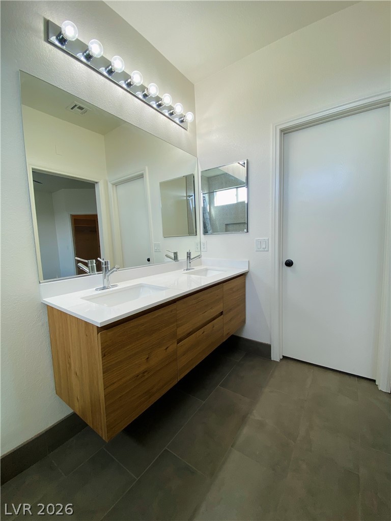 8794 Timber Mesa Street Las Vegas, NV 89139 - Photo 18 of 26 This bathroom offers a contemporary floating vanity with dual sinks, perfect for morning routines.