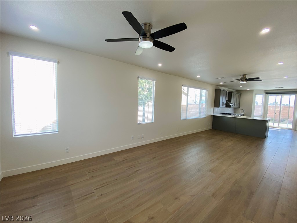 8794 Timber Mesa Street Las Vegas, NV 89139 - Photo 26 of 26 An open floor plan with hardwood floors connects the kitchen and living areas, offering effortless flow and natural light.
