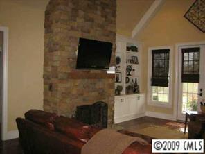 374 Nora Ridge Catawba, SC 29704 - Photo 5 of 8 a living room with a fireplace a flat screen tv and a floor to ceiling window
