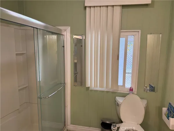 a bathroom with a toilet and a shower