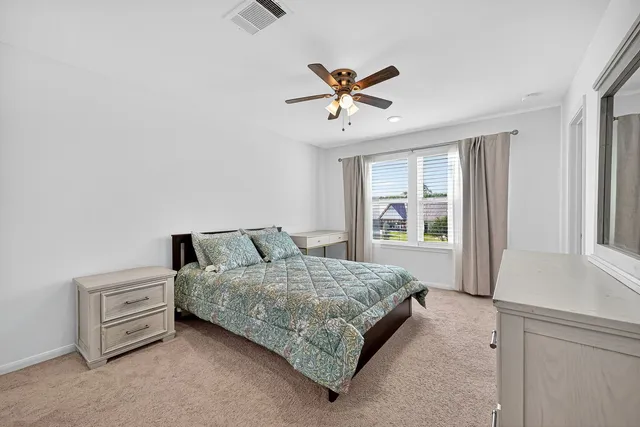 a bedroom with a bed dresser and a window