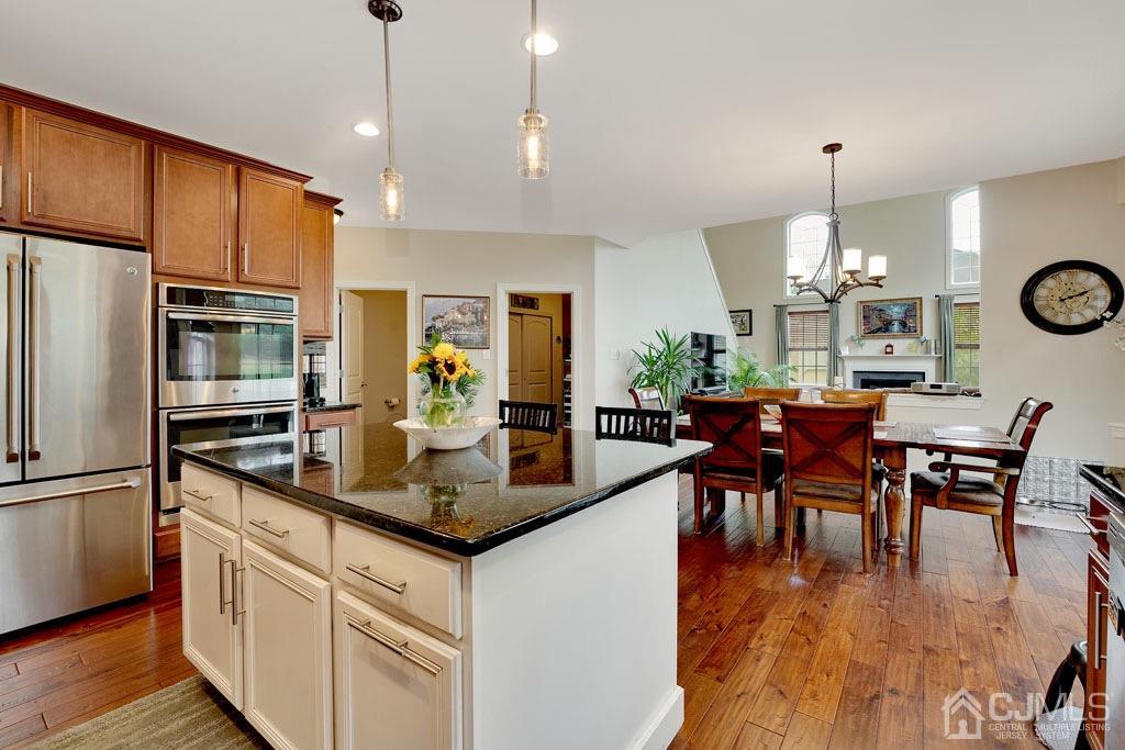 339 Ticetown Road Old Bridge, NJ 08857 - Photo 12 of 44 a kitchen with stainless steel appliances granite countertop a stove a refrigerator a kitchen island a dining table and chairs with wooden floor