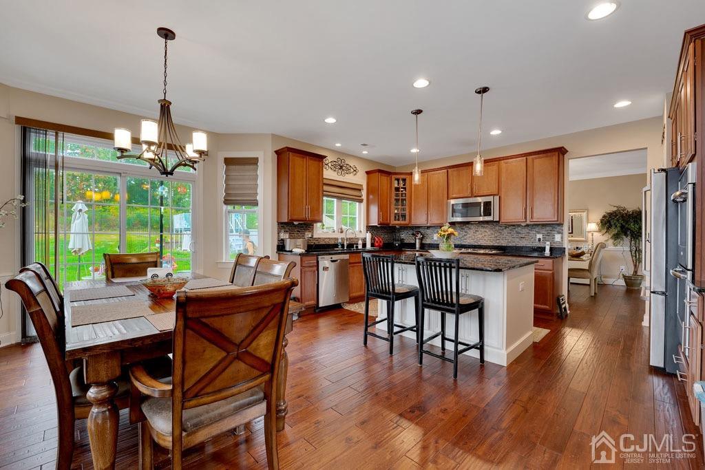 339 Ticetown Road Old Bridge, NJ 08857 - Photo 15 of 44 a kitchen with stainless steel appliances kitchen island granite countertop a stove a refrigerator a kitchen island a couches and chairs with wooden floor