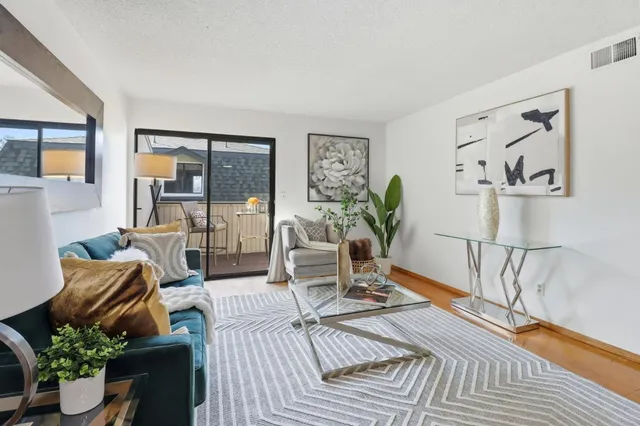 a dining room with furniture potted plants and wooden floor