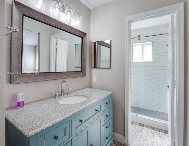 a bathroom with a granite countertop sink and a mirror