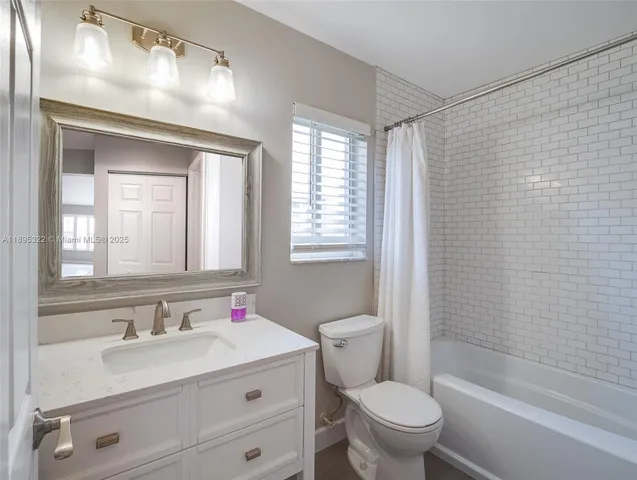 a bathroom with a granite countertop sink toilet a large mirror a shower and a bathtub