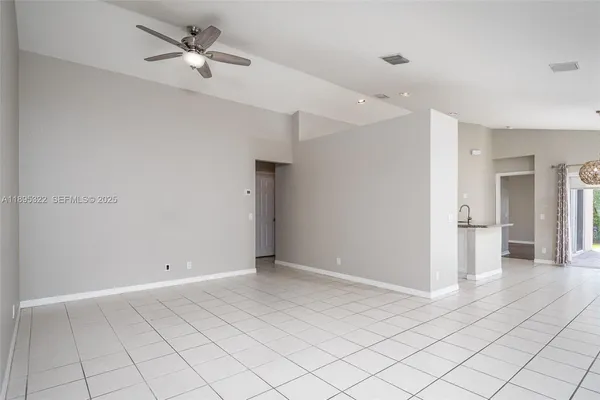 a view of a livingroom with a ceiling fan and entryway