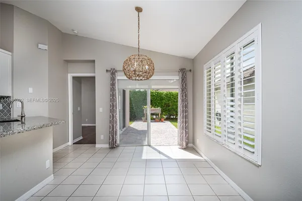 a view of a kitchen with granite countertop natural light fixtures and a large window