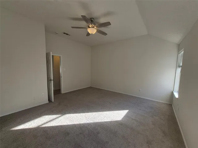 an empty room with a fan and a window