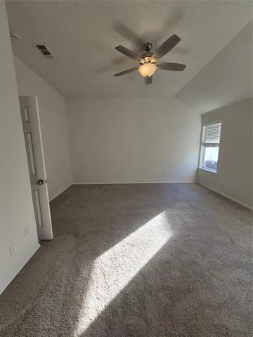 an empty room with windows and fan