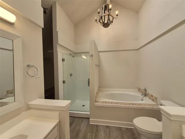 a bathroom with a granite countertop bathtub sink vanity mirror and toilet