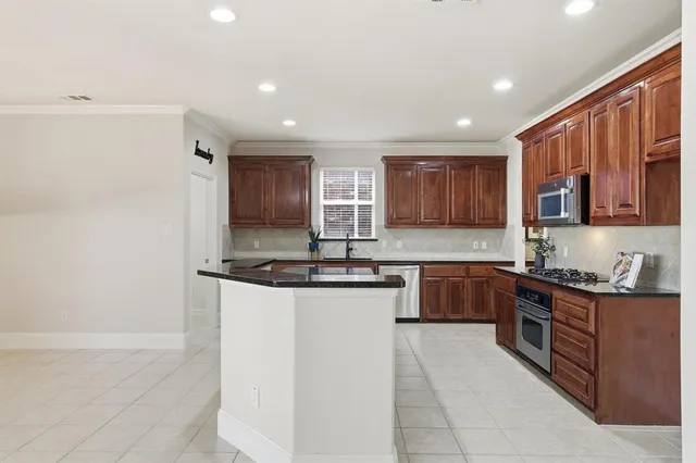 a kitchen with stainless steel appliances granite countertop a sink and stove top oven