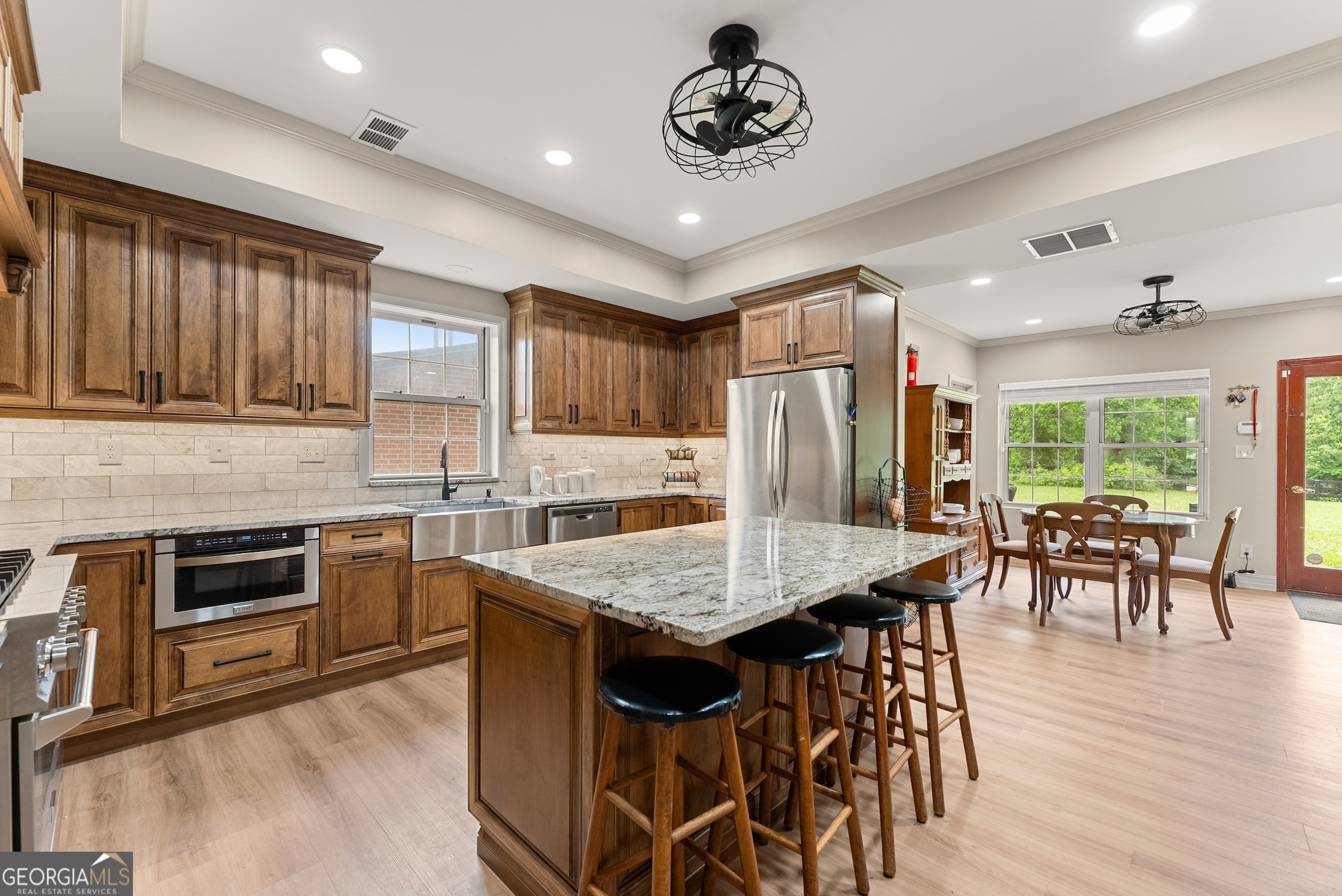 7215 Kelly Bridge Road Dawsonville, GA 30534 - Photo 8 of 81 a kitchen with stainless steel appliances granite countertop a stove a refrigerator a sink a dining table and chairs with wooden floor