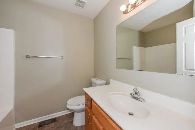 a bathroom with a sink a toilet and mirror