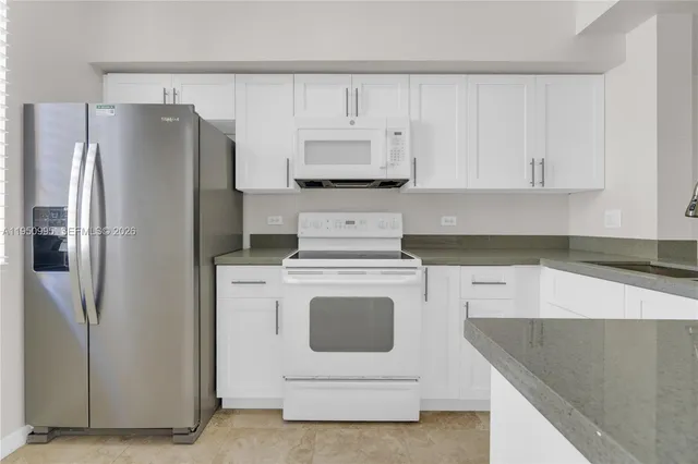 a kitchen with stainless steel appliances white cabinets and a refrigerator