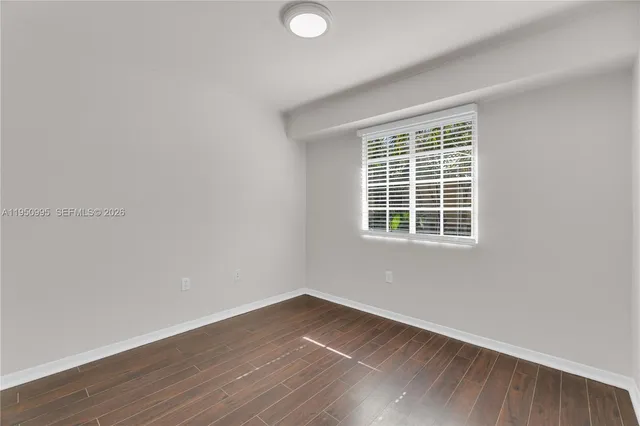 an empty room with wooden floor and closet