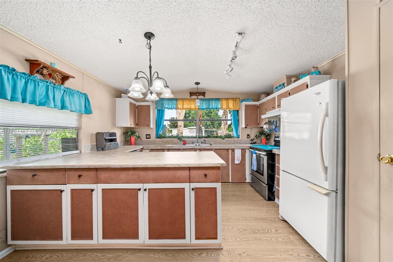 1145 Bluejay Road Wauchula, FL 33873 - Photo 2 of 42 a kitchen with refrigerator cabinets and a chandelier