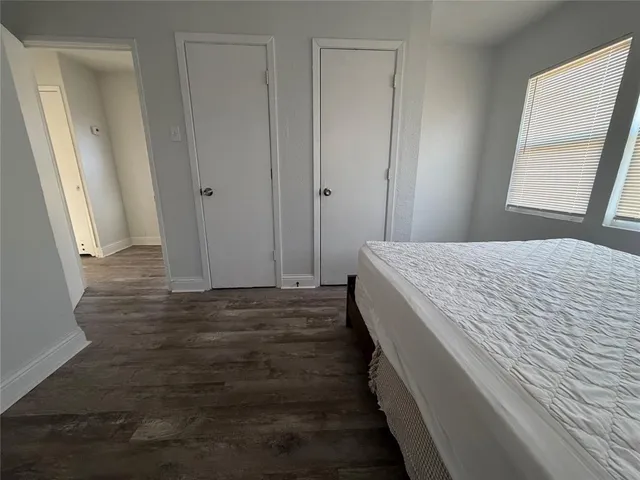 a room with a bed and wooden floor