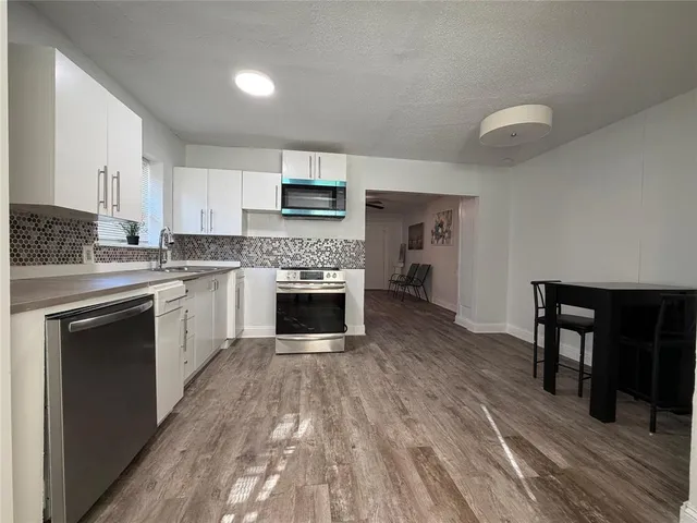 a kitchen with a stove top oven and sink