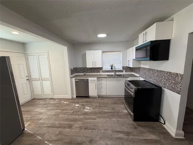 a kitchen with a stove top oven and refrigerator