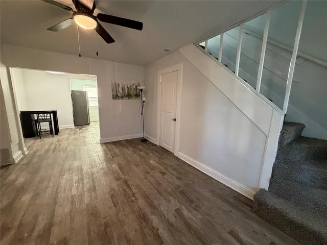 a view of a livingroom with wooden floor and a ceiling fan