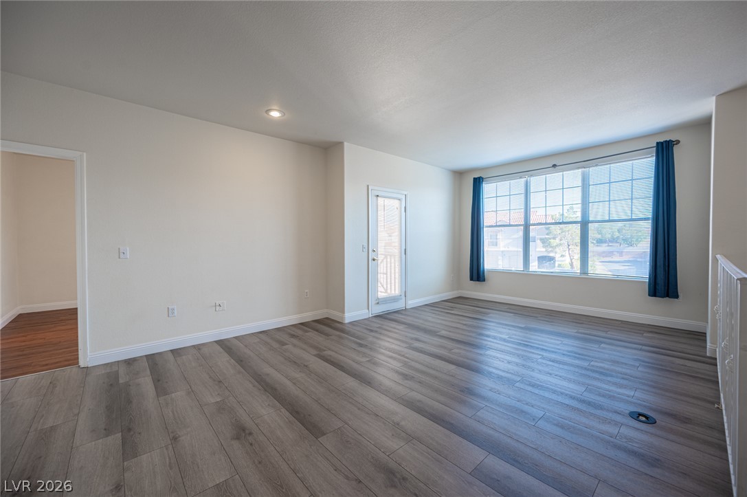 8555 West Russell Road, Unit 2062 Las Vegas, NV 89113 - Photo 6 of 35 A naturally illuminated living area features sleek wood flooring and a convenient outdoor access door.