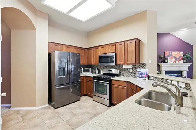 a kitchen with stainless steel appliances granite countertop a refrigerator sink and microwave