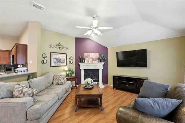 a living room with furniture a fireplace and a flat screen tv