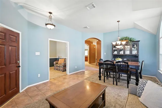 a dining room with furniture a chandelier and window