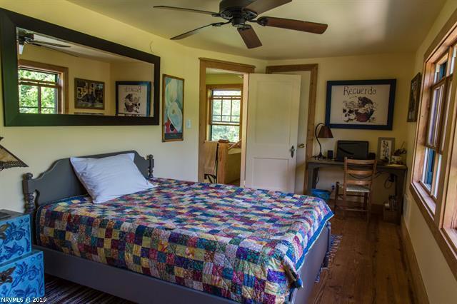 2094 Union School Road Southwest Willis, VA 24380 - Photo 12 of 40 a bedroom with a bed a dresser and floor to ceiling window