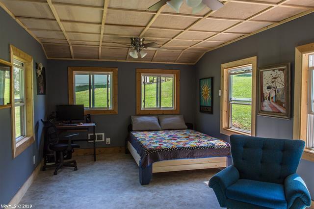 2094 Union School Road Southwest Willis, VA 24380 - Photo 25 of 40 a bedroom with a bed wooden floor and windows