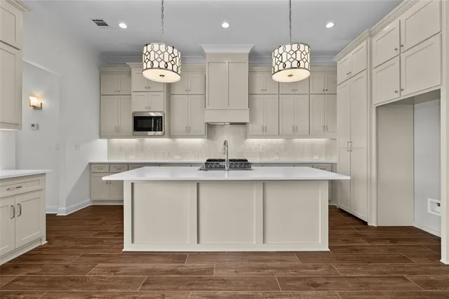 a view of kitchen with granite countertop cabinets a sink and a chandelier
