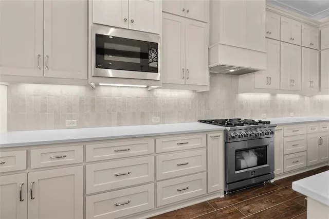 a kitchen with granite countertop white cabinets and stainless steel appliances