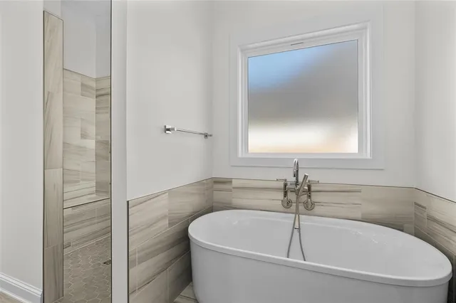 a spacious bathroom with a double vanity sink a large mirror and shower