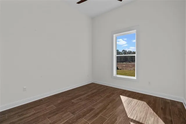 a view of an empty room with closet and windows