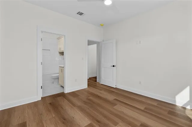 an empty room with a window and ceiling fan