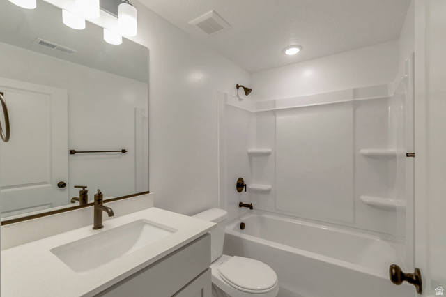 30 South Moonlit Road Mapleton, UT 84664 - Photo 16 of 25 Bathroom featuring a white bathtub with integrated shower, a vanity with a rectangular undermount sink, solid surface countertop, and bronze-finish fixtures