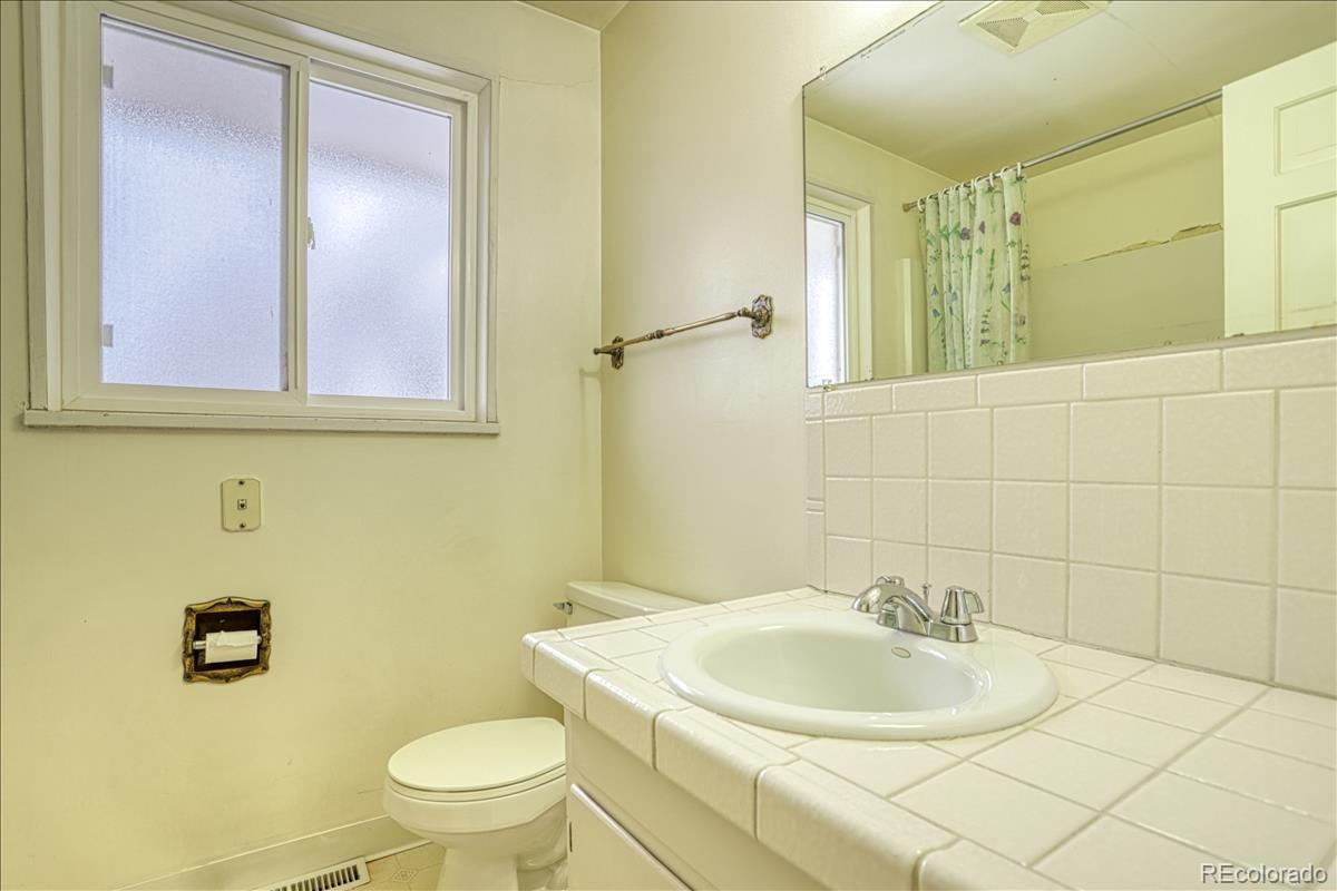 1279 West Ridge Road Littleton, CO 80120 - Photo 11 of 16 a bathroom with a sink toilet and mirror