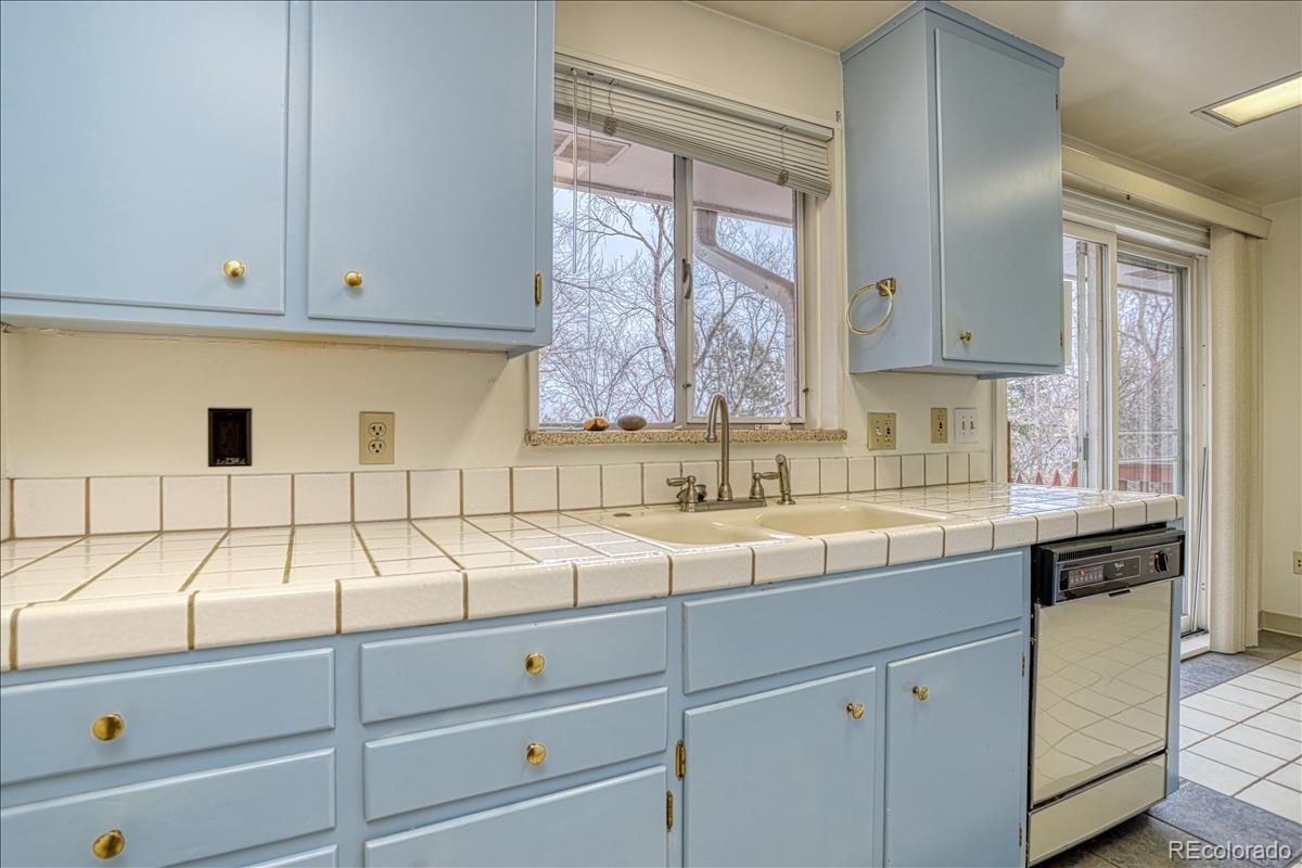 1279 West Ridge Road Littleton, CO 80120 - Photo 6 of 16 a kitchen with white cabinets and window