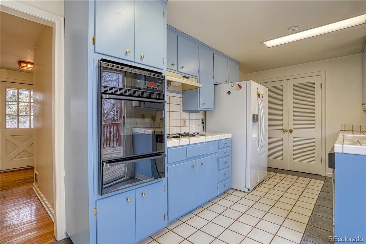 1279 West Ridge Road Littleton, CO 80120 - Photo 7 of 16 a kitchen with stainless steel appliances a refrigerator and a stove top oven