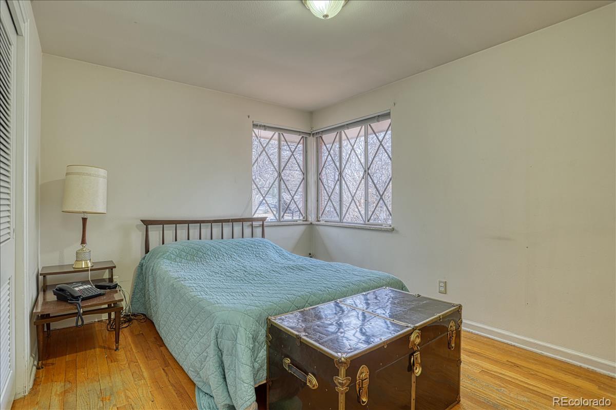 1279 West Ridge Road Littleton, CO 80120 - Photo 10 of 16 a bed sitting in a bedroom next to a window