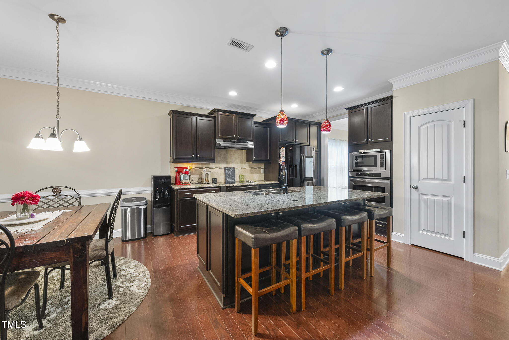728 Spruce Meadows Lane Willow Spring, NC 27592 - Photo 9 of 45 a kitchen with stainless steel appliances granite countertop a stove a refrigerator a kitchen island a dining table and chairs with wooden floor