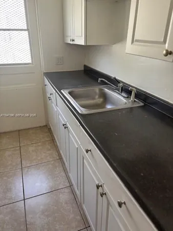 a kitchen with a sink a counter top space and cabinets