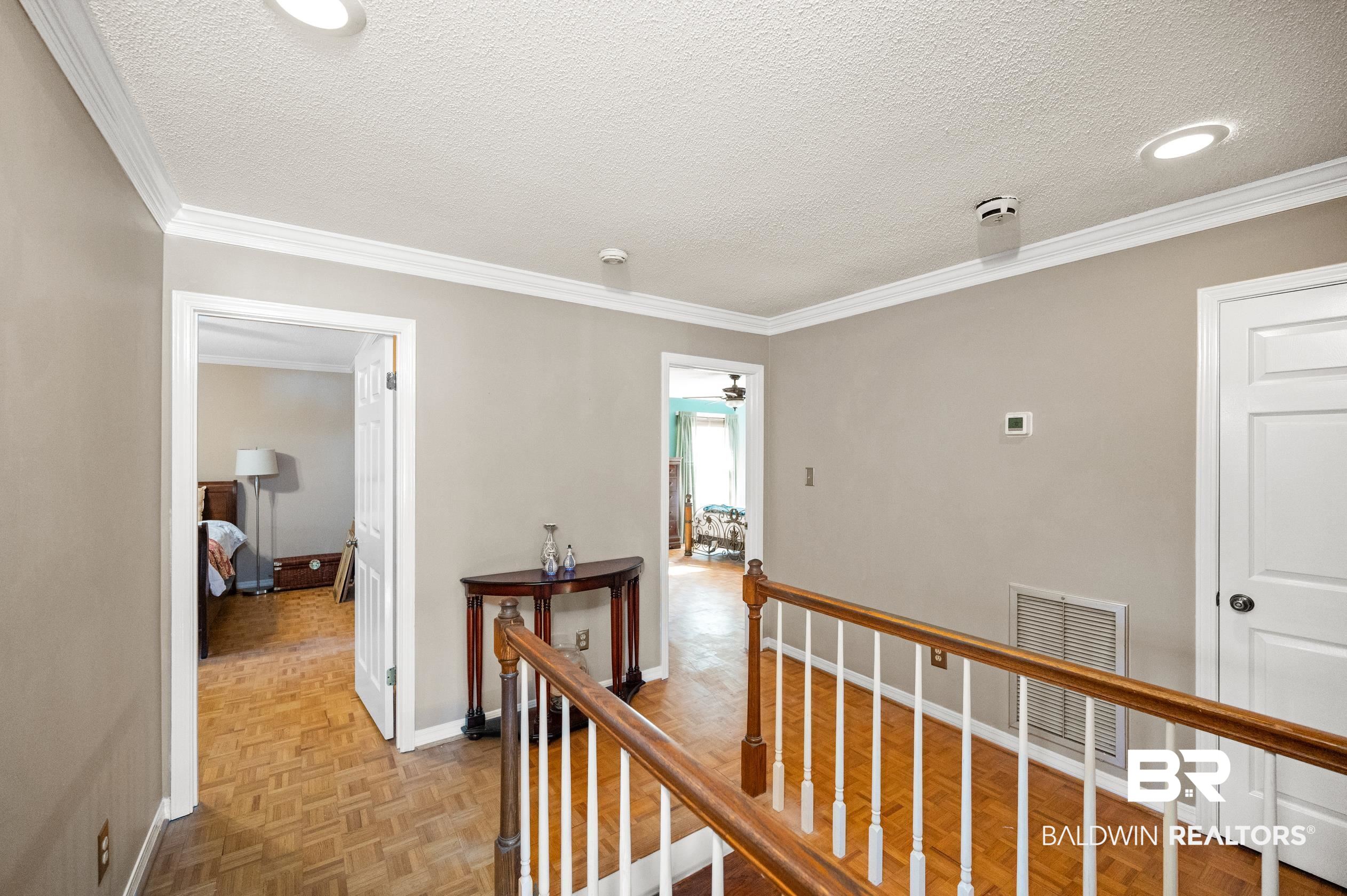 6705 Ridgeland Road South Mobile, AL 36695 - Photo 30 of 44 Hallway featuring ornamental molding, a textured ceiling, and light parquet flooring